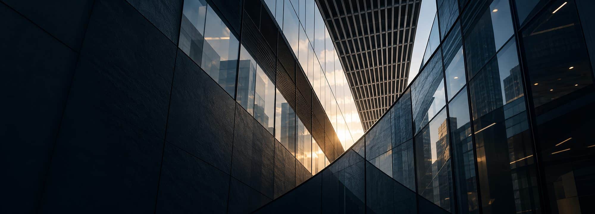 Abstract view of glass office towers converging at sunset